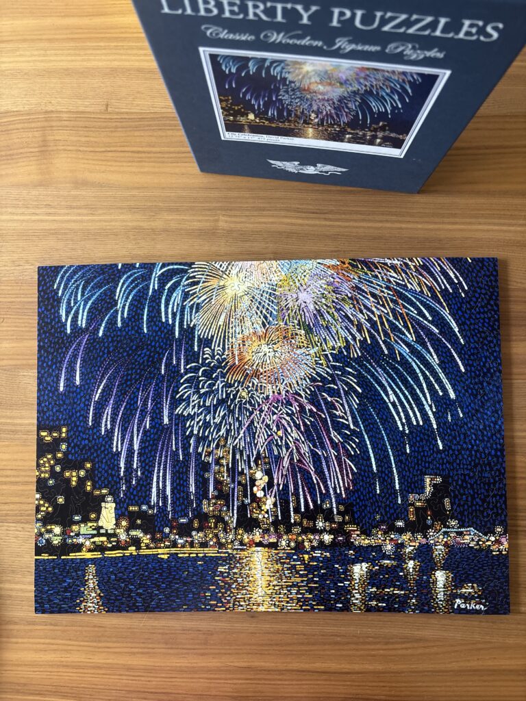 Picture of a completed jigsaw puzzle featuring a night skyline and fireworks