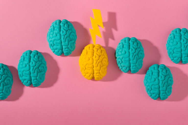 Illustration of brains lined up, one outlier with a lightning bolt
